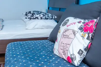 a pillow with the word love sitting on a bed at Studio Koral in Soko Banja