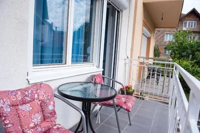 a balcony with a table and chairs and a window at Studio Koral in Soko Banja