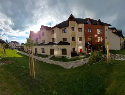 a large building with a green yard in front of it at AM apartments in Kopaonik