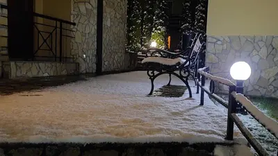 a room covered in snow with a table and lights at Apartman Modena Lux in Vrnjačka Banja
