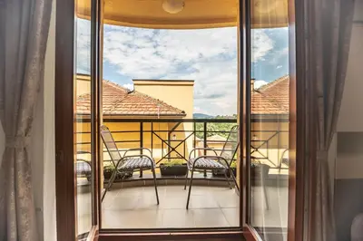 a balcony with chairs and a view of a house at Apartman Modena Lux in Vrnjačka Banja