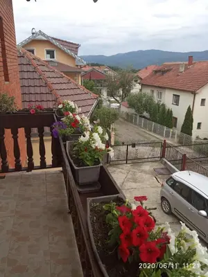 a balcony with flowers inpots on a fence at Konak Mali Raj in Vrnjačka Banja