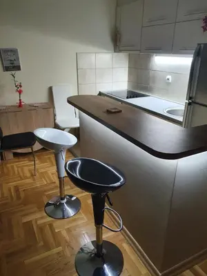 a kitchen with two bar stools and a counter top at Stankovic apartman in Niš