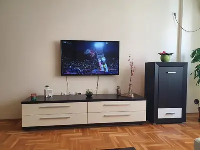 a living room with a tv on a wall at Stankovic apartman in Niš