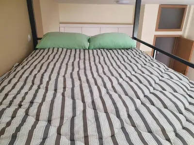 a bed with two green pillows on top of it at Stankovic apartman in Niš