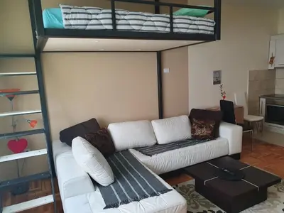 a living room with a couch and a loft bed at Stankovic apartman in Niš