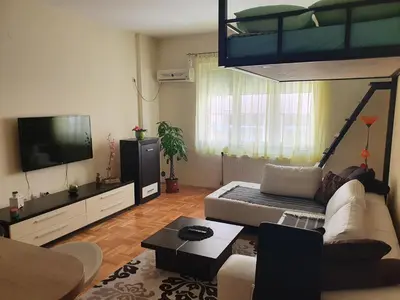 a living room with a couch and a loft bed at Stankovic apartman in Niš