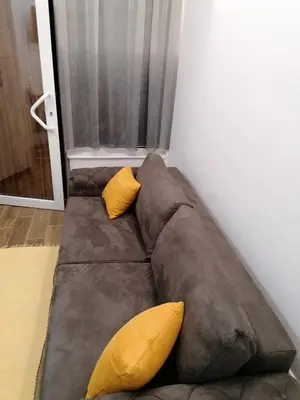 a brown couch with two yellow pillows on it at Studio Simonovic in Vrnjačka Banja