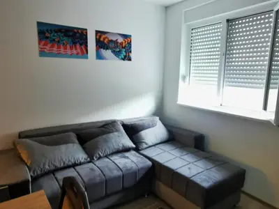 a living room with a couch and a window at Cozy Corner Apartments - Free parking & Wi-fi in Ćuprija