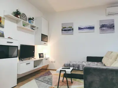 a white room with a bed and a tv at Cozy Corner Apartments - Free parking & Wi-fi in Ćuprija