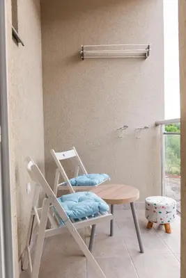 a rocking chair and a table in a room at Studio Borići in Soko Banja