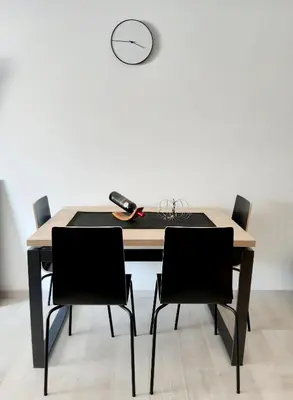 a dining room table with black chairs and a clock at Kopaonik Milmari L42 in Kopaonik
