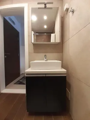 a bathroom with a sink and a mirror and a door at Kopaonik Milmari L42 in Kopaonik