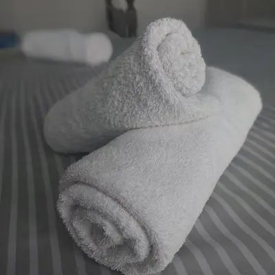 a white towel sitting on top of a bed at Apartman Tadeus in Soko Banja