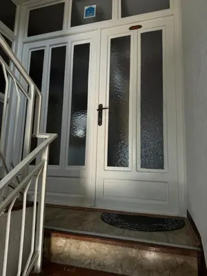 a white door with glass windows and a staircase at Apartman Tadeus in Soko Banja