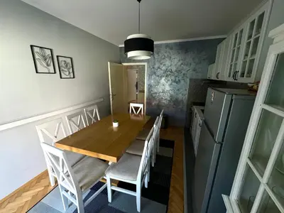 a kitchen and dining room with a wooden table and chairs at Apartman Tadeus in Soko Banja