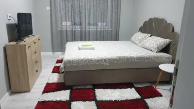 a bedroom with a bed and a dresser and a television at Apartman Sweet dreams 2 in Niš