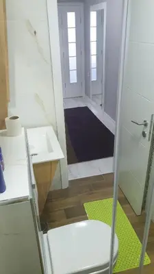 a bathroom with a toilet and a sink and a mirror at Apartman Sweet dreams 2 in Niš