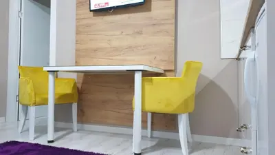 a white table and two yellow chairs in a room at Apartman Sweet Dreams 3 in Niš