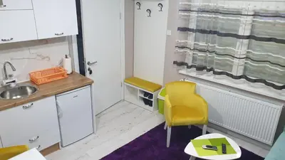 a small kitchen with a sink and a yellow chair at Apartman Sweet Dreams 3 in Niš