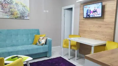 a living room with a blue couch and a table at Apartman Sweet Dreams 3 in Niš
