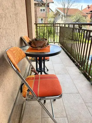 a table and chairs sitting on a balcony at IDI MI - DODJI MI in Vrnjačka Banja