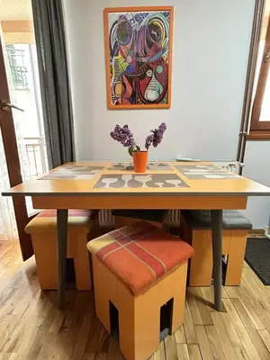 a dining room table with a flower vase on it at IDI MI - DODJI MI in Vrnjačka Banja