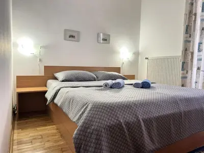 a bedroom with a bed with blue towels on it at IDI MI - DODJI MI in Vrnjačka Banja