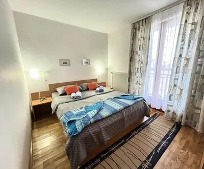 a bedroom with a bed and a large window at IDI MI - DODJI MI in Vrnjačka Banja