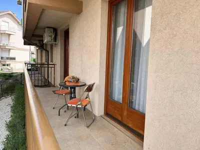a balcony with a table and chairs next to a door at IDI MI - DODJI MI in Vrnjačka Banja