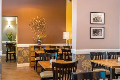 a dining room with wooden tables and chairs at Vila Emilia in Vrnjačka Banja