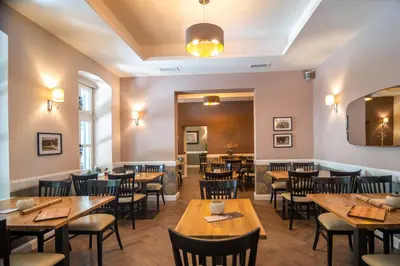 a restaurant with wooden tables and chairs at Vila Emilia in Vrnjačka Banja