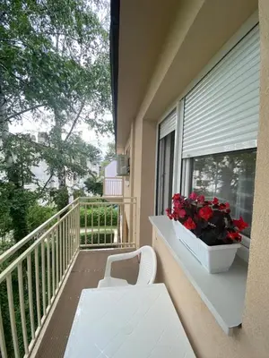 a balcony with a white bench and a window with flowers at Don in Vrnjačka Banja