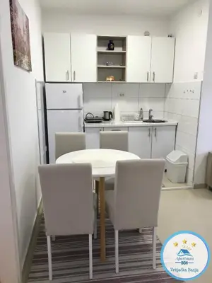 a kitchen with a table and chairs in a room at Don in Vrnjačka Banja