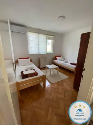 a small room with two beds and a table at Don in Vrnjačka Banja