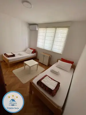 a small room with two beds and a window at Don in Vrnjačka Banja