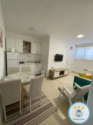 a kitchen and living room with a table and chairs at Don in Vrnjačka Banja