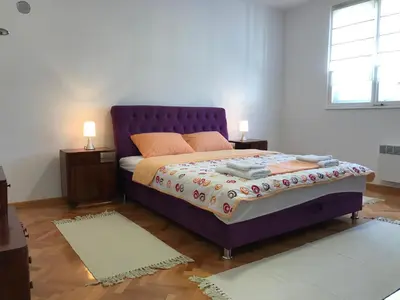 a bedroom with a purple bed and two night stands at Don in Vrnjačka Banja