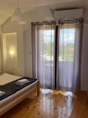 a bedroom with a bed and a large window at Apartman Jovana in Soko Banja