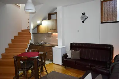 a living room with a couch and a table and a kitchen at Apartman Jovana in Soko Banja