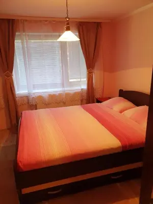 a bedroom with two beds in front of a window at Apartman Sergej 2 in Soko Banja