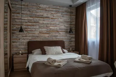 a bedroom with a bed and a brick wall at Apartments Due Mondi in Vrnjačka Banja
