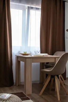 a wooden table with two chairs next to a window at Apartments Due Mondi in Vrnjačka Banja