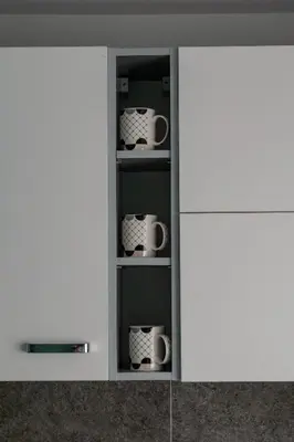 a cupboard with three mugs in it at Apartments Due Mondi in Vrnjačka Banja