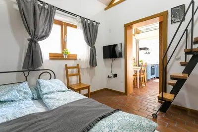 a bedroom with a bed with blue pillows and a television at Kompleks apartmana SuperStar23A in Soko Banja