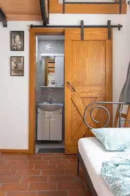 a bathroom with a wooden door and a sink at Kompleks apartmana SuperStar23A in Soko Banja