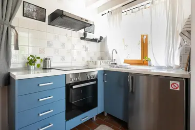 a kitchen with blue cabinets and a dishwasher at Kompleks apartmana SuperStar23A in Soko Banja