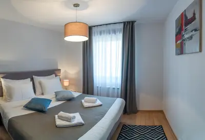 a bedroom with a large bed with two towels on it at Apartman Favorito 327 in Vrnjačka Banja