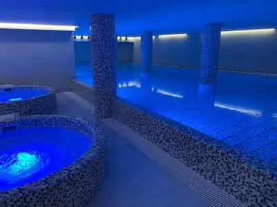 a swimming pool with blue lights in a building at Apartman Favorito 327 in Vrnjačka Banja