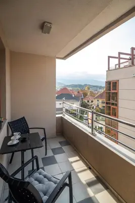 a balcony with a table and chairs and a view at Apartman Favorito 327 in Vrnjačka Banja